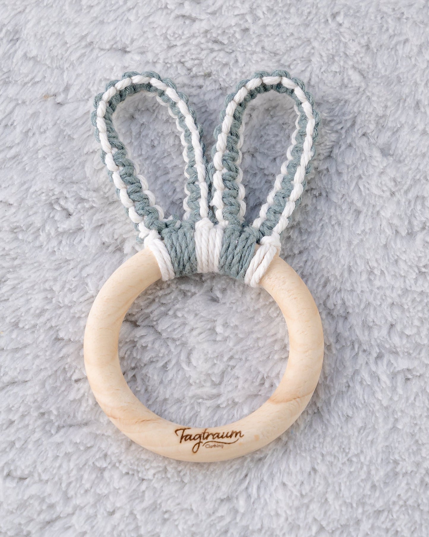 Holz Greifling für Babys mit süssen Hasenohren aus Makramee Garn in Eukalyptus-Grün und Ecru, handgefertigt in der Schweiz von Tagtraum Clothing.