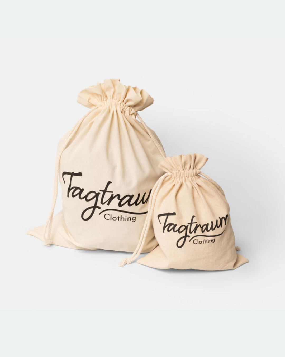 Ein Set aus zwei unterschiedlich grossen Bio-Baumwollbeuteln mit einem schwarzenTagtraum Clothing Print