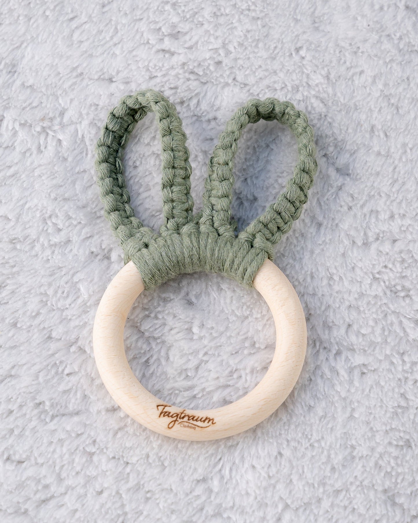 Süsses Hasenohren Greifling für Babys, aus einem schönen Holzring mit edler Tagtraum Gravur und Hasenohren aus Makrameegarn in schönem Eukalyptus-Grün, handgefertigt in der Schweiz von Tagtraum Clothing