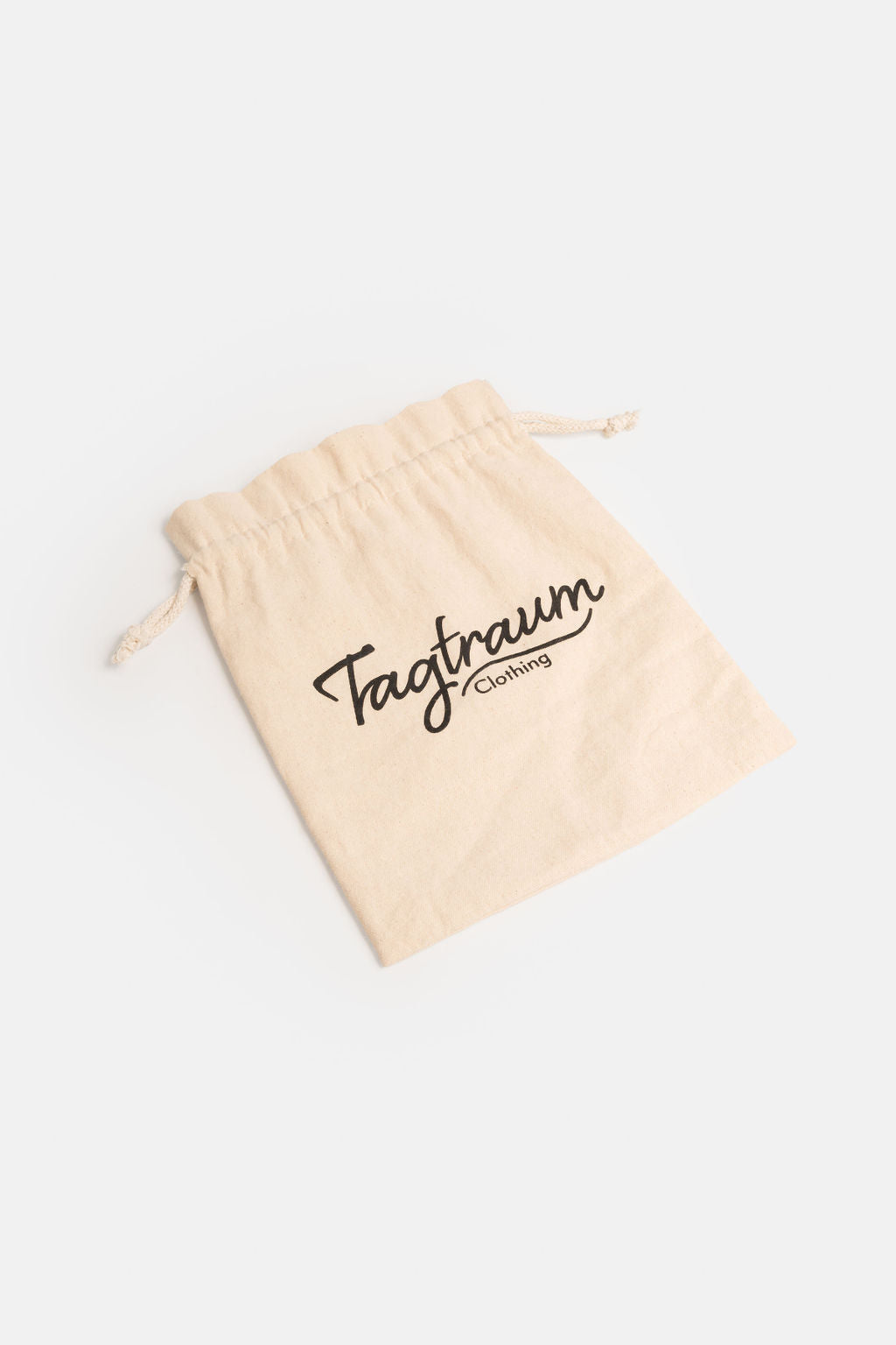 Ein kleiner Bio-Baumwollbeutel, naturfarben, mit schwarzem Tagtraum clothing Print