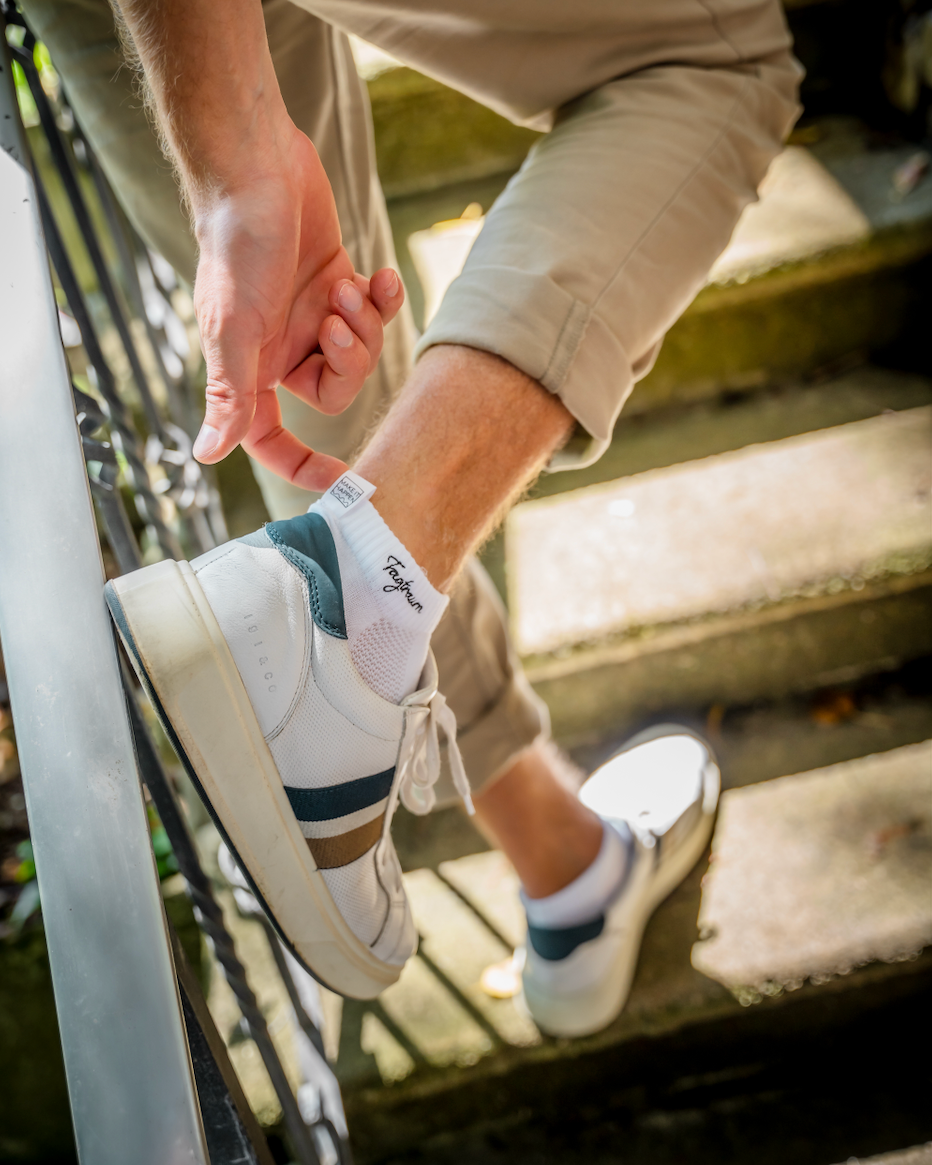 Sneakersocken in weiss mit edlem Tatraum Stick in schwarz und unserer coolen Make-it-happen-Lasche, getragen in edlen, weissen Sneaker