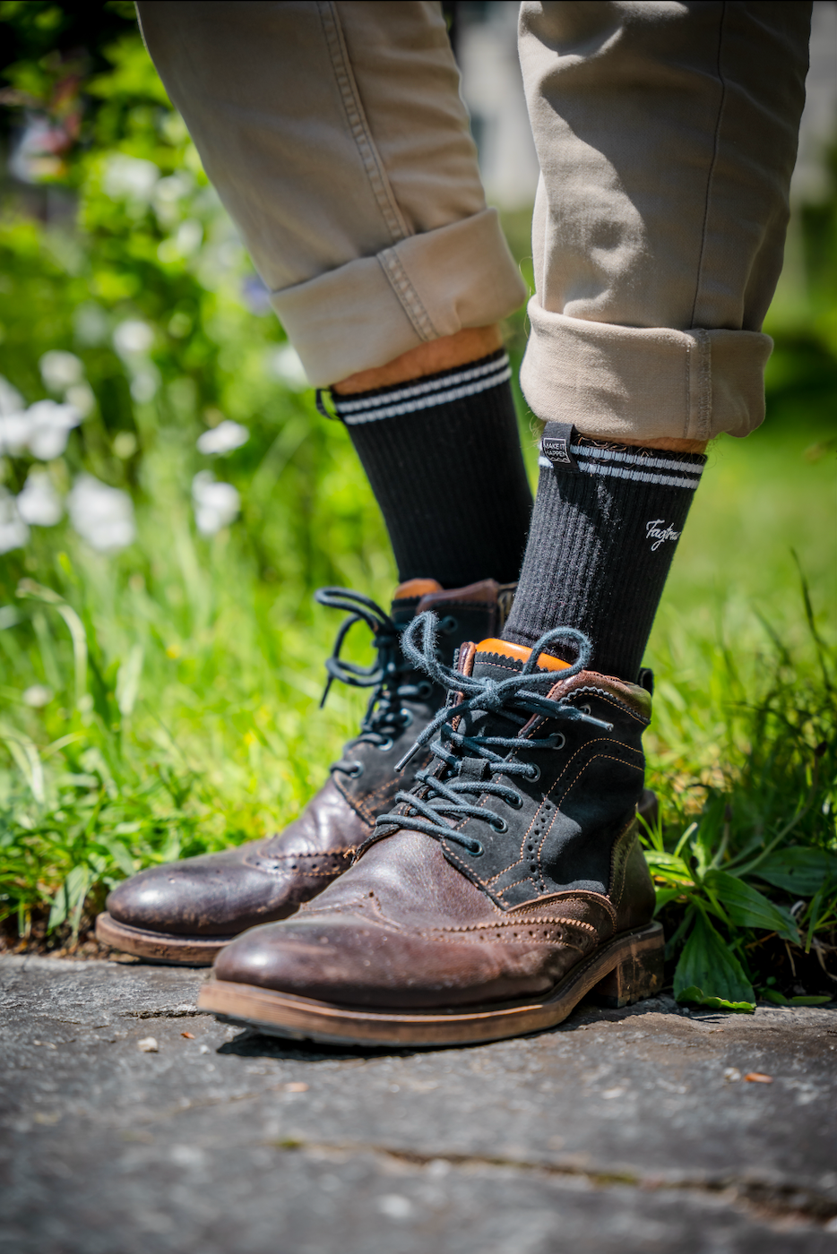 Schwarze Tennissocken mit edlem, weissen Tagtraum Stick, getragen von einem Mann in coolen Boots