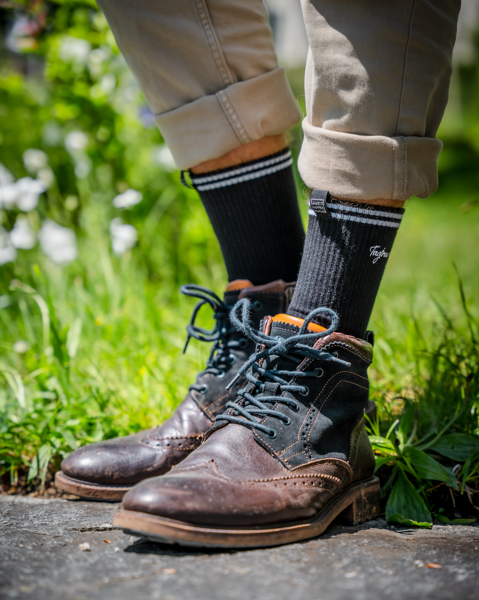 Schwarze Tennissocken mit edlem, weissen Tagtraum Stick, getragen von einem Mann in coolen Boots