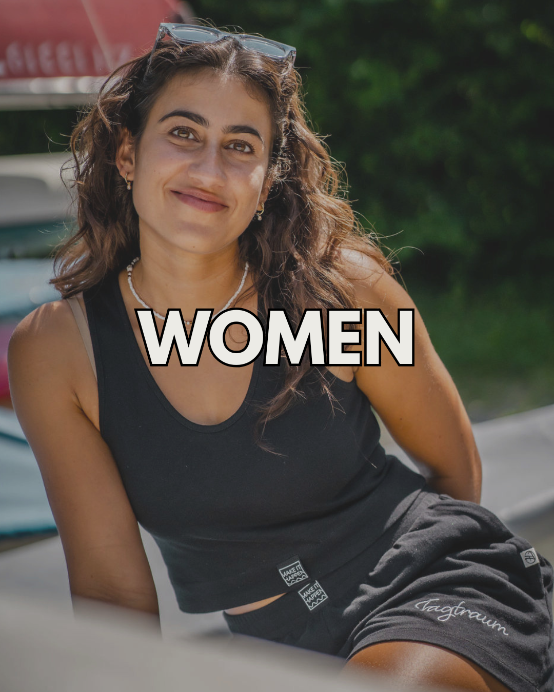 Ein weibliches Model in einer Schneelandschaft mit einem graublauen Tagtraum Beanie und einem schwarzen Unisex Shirt von Tagtraum, darüber ein Wintermantel