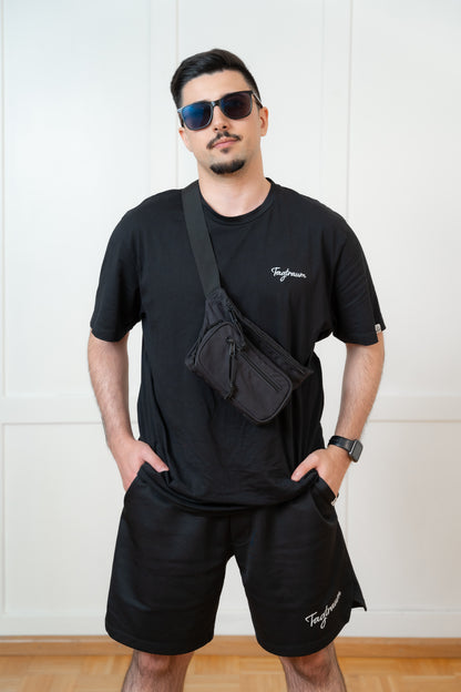 Shirts und Shorts in schwarz mit weissem Tagtraum Stick; cool getragen im Streetstyle Look mit crossbody bag, Sonnenbrille und smart watch
