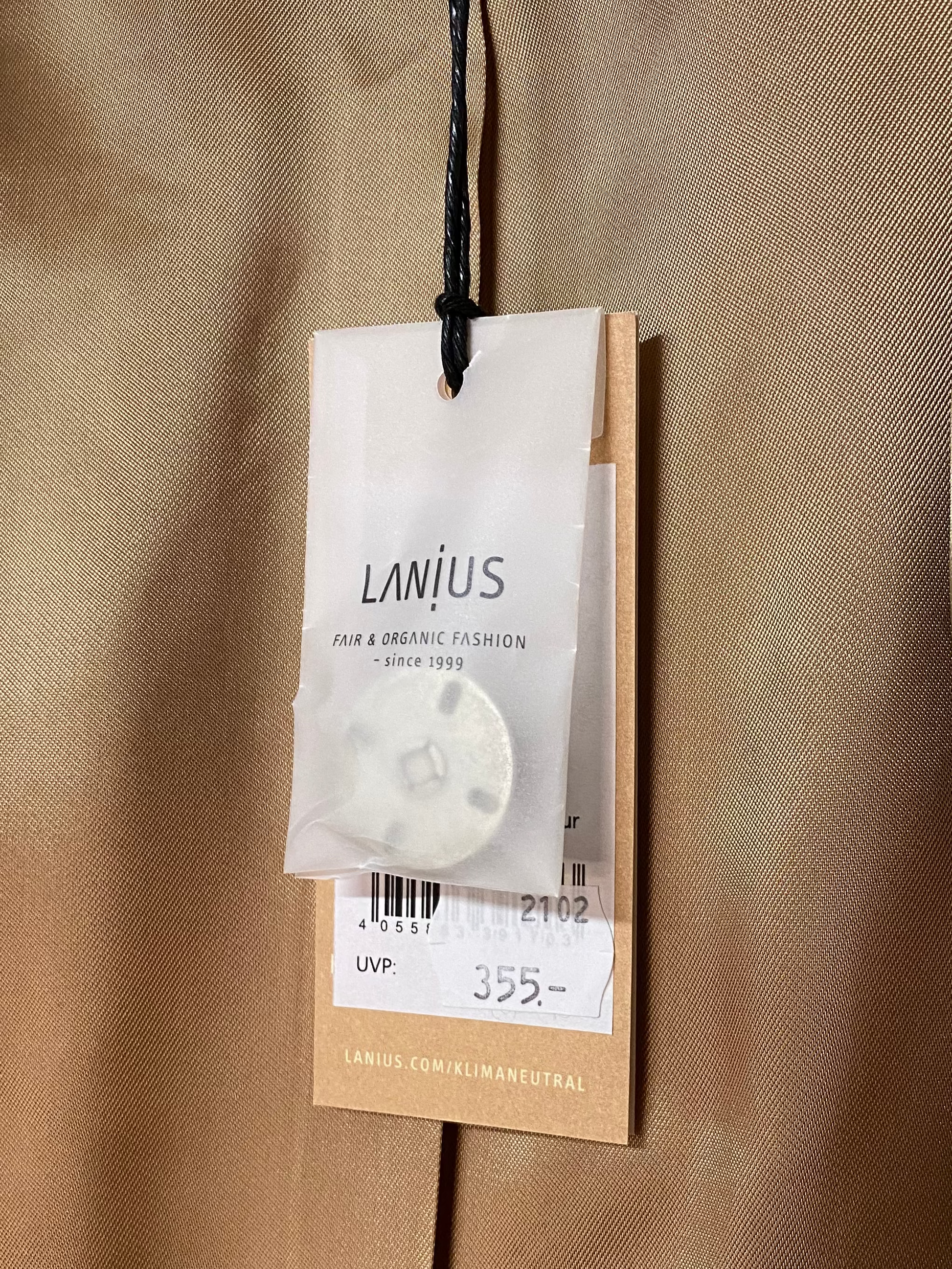 Hang Tag mit Ersatzknopf und Preisangabe eines Wollmantels von der Marke Lanius.