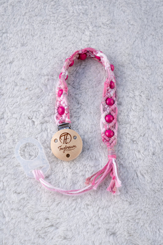 Schöne Schnullerkette aus rosa Garn mit pinken Holzperlen, einem hochwertigen Schnullerclip aus Holz, und einem Adapter für MAM Schnuller. Auf dem Holzclip befindet sich eine dle Tagtraum Cothing Gravur mit Logo. Die Schnullerketten werden handgefertigt von Tagtraum Clothing in der Schweiz.