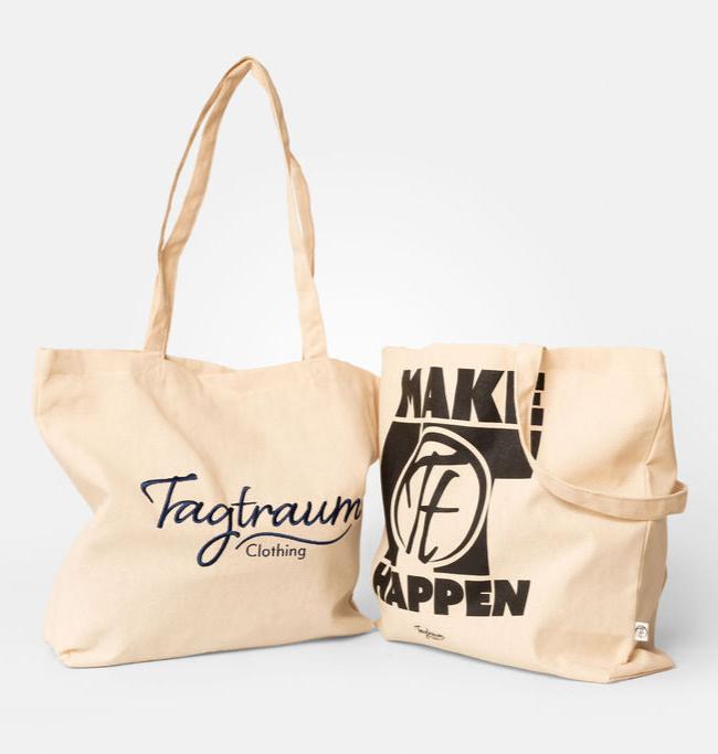 Zwei Shopper aus 100% Bio-Baumwolle, naturfarben, eine mit edlem, dunkelblauem Tagtraum Clothing Stick und eine mit schwarzem, coolen "Make it happen" Print