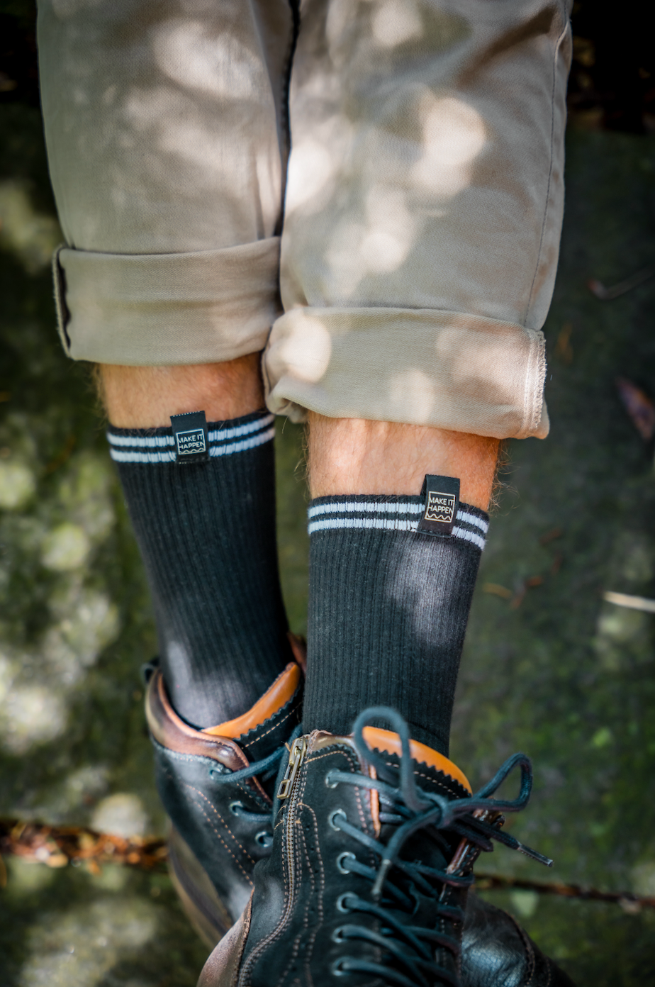 Schwarze Tennis Socken, mit dem coolen Make-It-Happen-Label vorne und zwei weissen Streifen. Getragen mit Stoffhosen und Boots